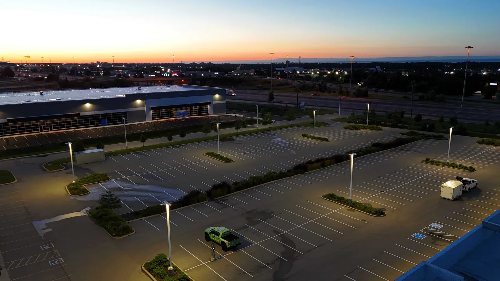 A commercial parking lot with freshly painted stalls photographed in the evening